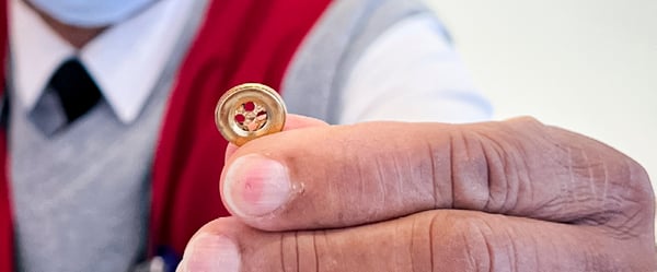 Volunteer holding a gold button